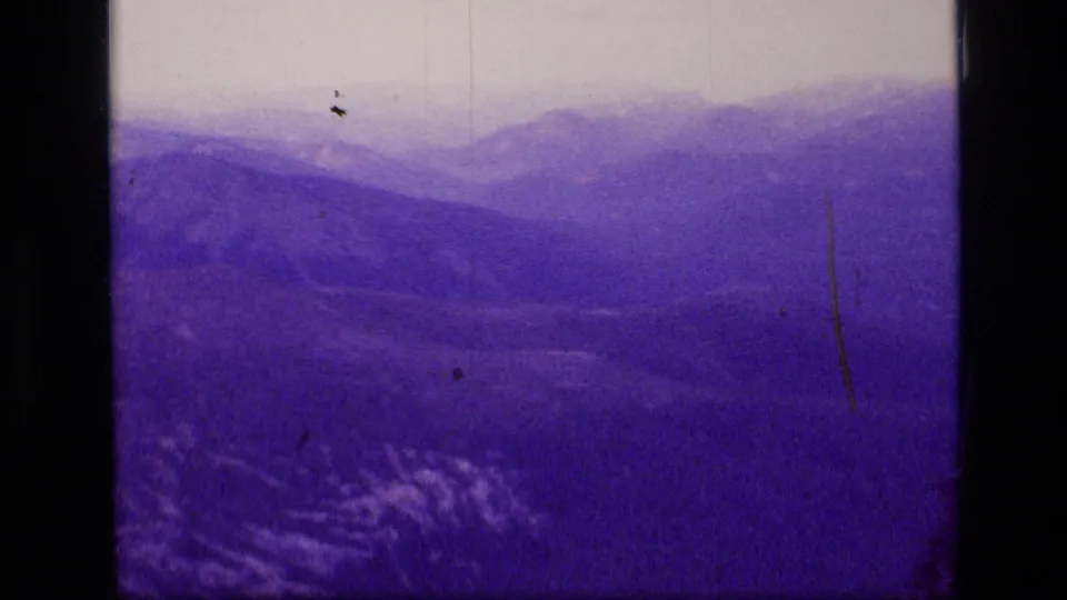 Scapegoat Wilderness mountain view on 8mm film, showing muted ridges, shadowed foreground, and visible age marks.