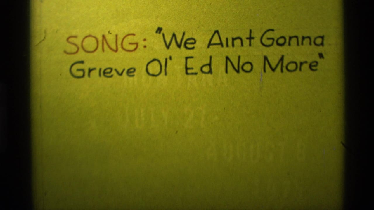 1975 Agate Springs, Montana 8mm frame showing a handwritten card reading the song title We Ain't Gonna Grieve Ol' Ed No More.