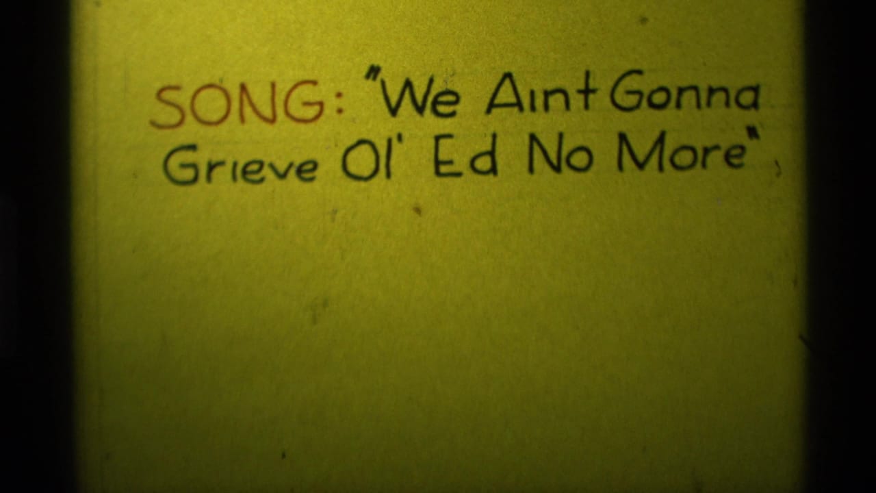 Yellow handwritten title card with song text and dark vertical film edges.