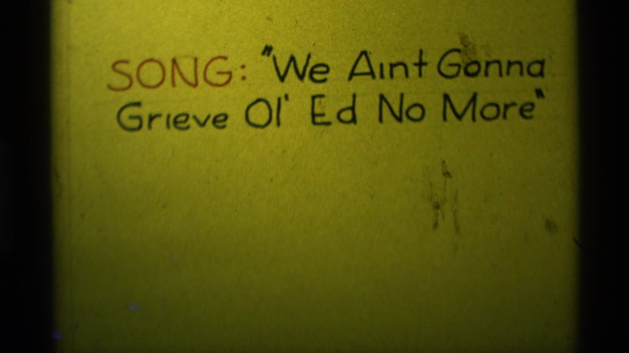 1975 Agate Springs 8mm frame showing a close handwritten song title card on yellow paper with red and black lettering.