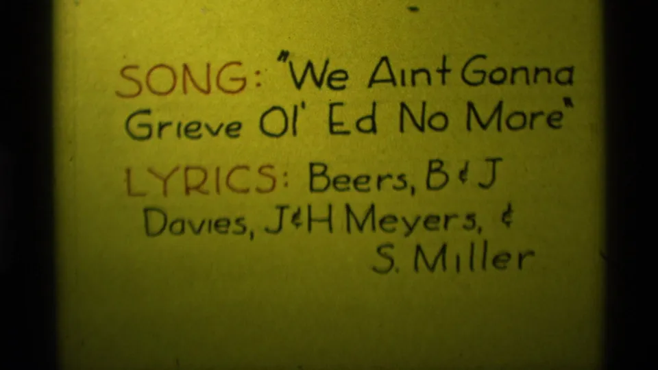 Final 1975 8mm frame of the yellow song card, with title and lyricist credits held in a steady close-up.