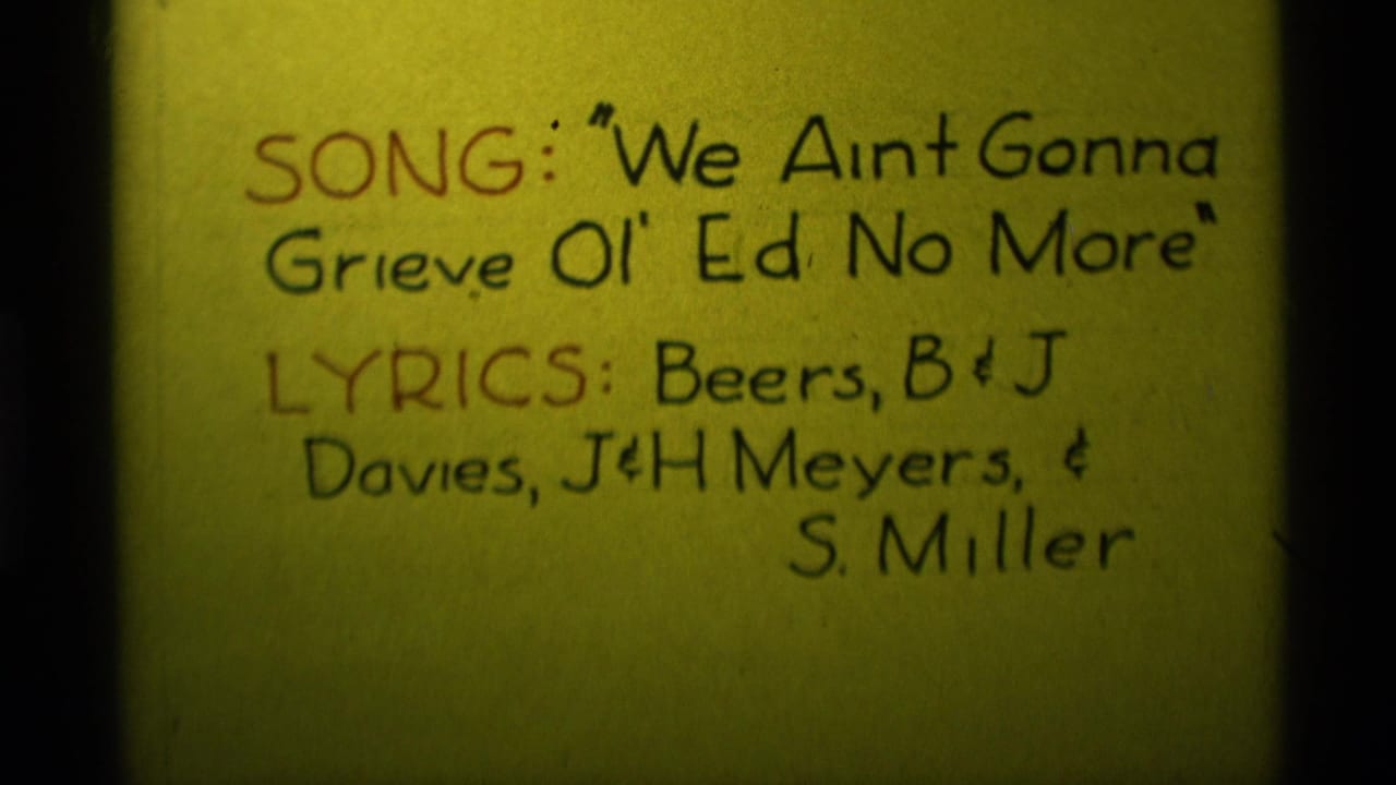 1975 Agate Springs, Montana 8mm frame showing a yellow handwritten song title card with lyric credits in black and red ink.