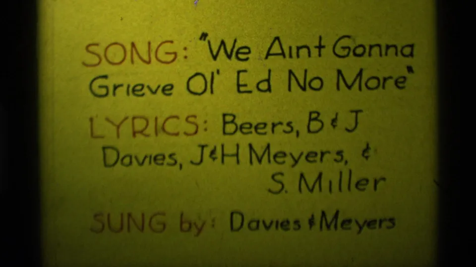 Close 1975 8mm view of the handwritten song card, with title, lyric credits, and Davies & Meyers singer credit visible.
