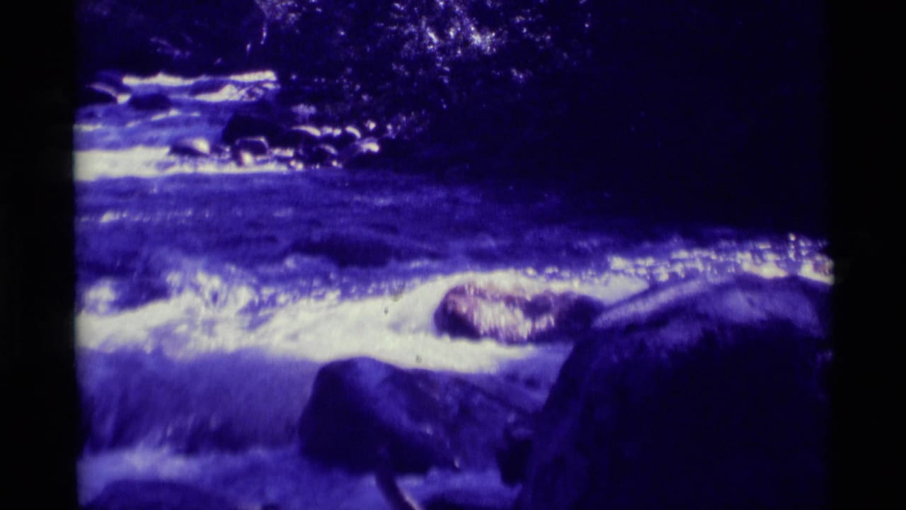 1975 8mm Agate Springs, Montana footage shows a fast river current breaking into white foam around dark rocks.