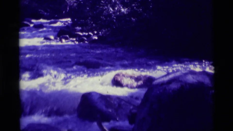 1975 8mm Agate Springs, Montana footage shows a fast river current breaking into white foam around dark rocks.