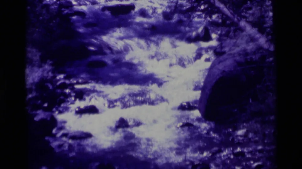 Close 1975 home-movie view of mountain water cascading over stones and boulders in Agate Springs, Montana.