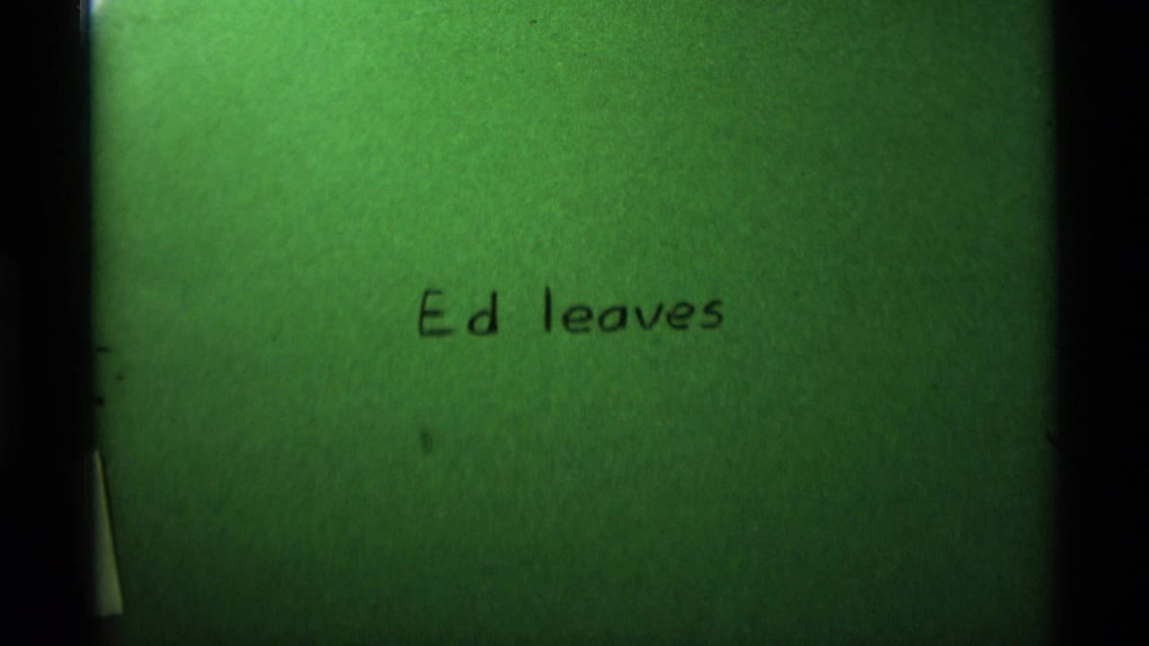 1975 8mm home-movie title card with handwritten text reading Ed leaves, tinted green with visible film borders.