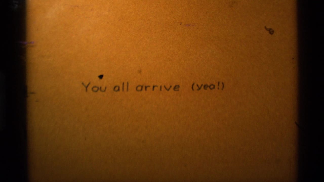 1975 8mm home-movie title frame from Agate Springs, Montana, with handwritten or typed text reading “You all arrive (yea!)”.