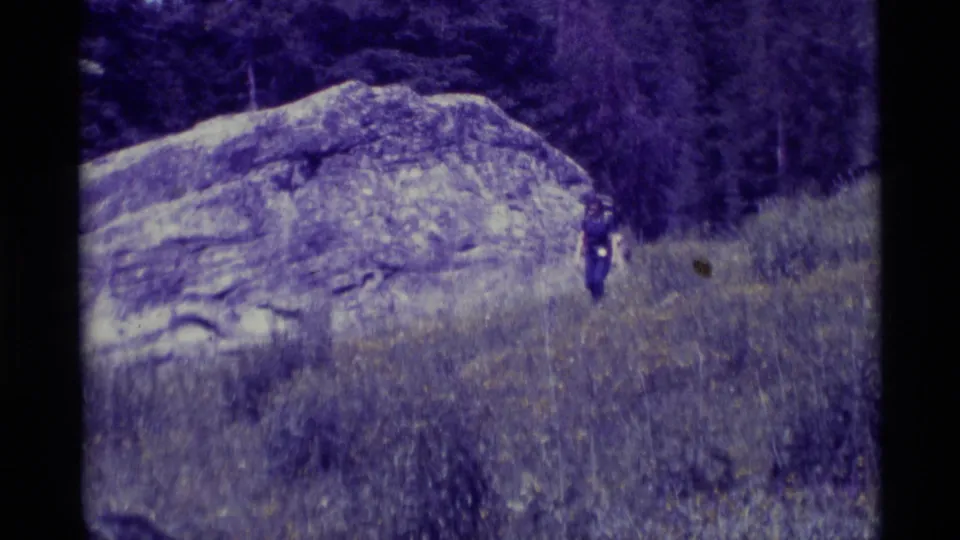A distant hiker appears beside a large rock formation in the Agate Springs, Montana landscape at the end of the clip.