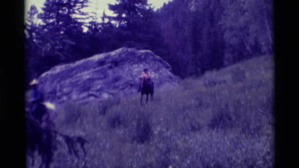 In this 1975 Agate Springs frame, the handheld camera catches a rider partly leaving frame as another rider remains near the boulder.