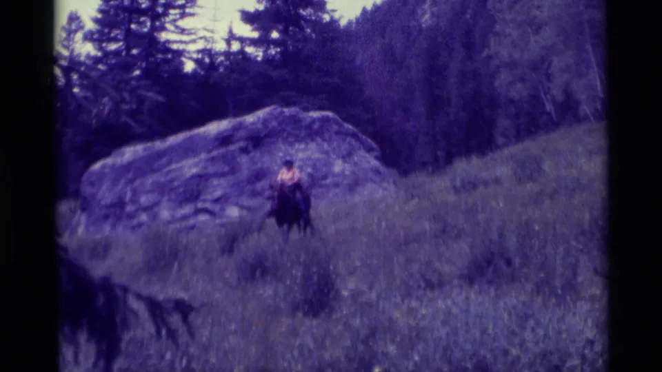 The final 1975 Montana frame shows a horseback rider near the center of a grassy hillside, with the rock outcrop and trees behind.