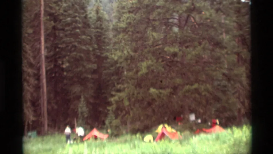 Wide 8mm view of the Agate Springs campsite, with campers and colorful tents set against dense trees.