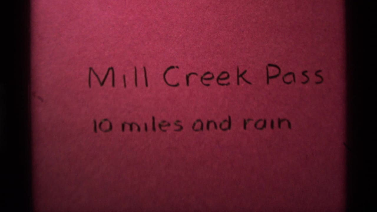 Handwritten 1975 title card identifies Mill Creek Pass with the weather note 10 miles and rain.