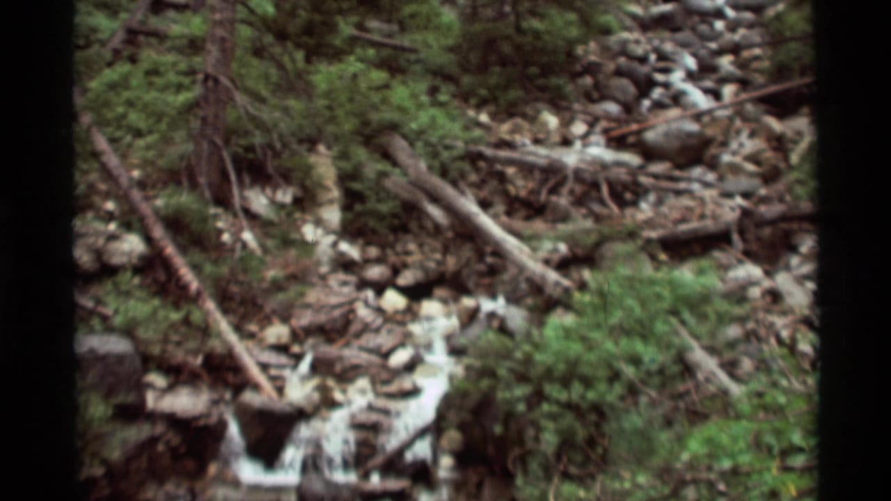 Rocky stream cascading through forested terrain in Agate Springs, Montana, from 1975 8mm home-movie footage.