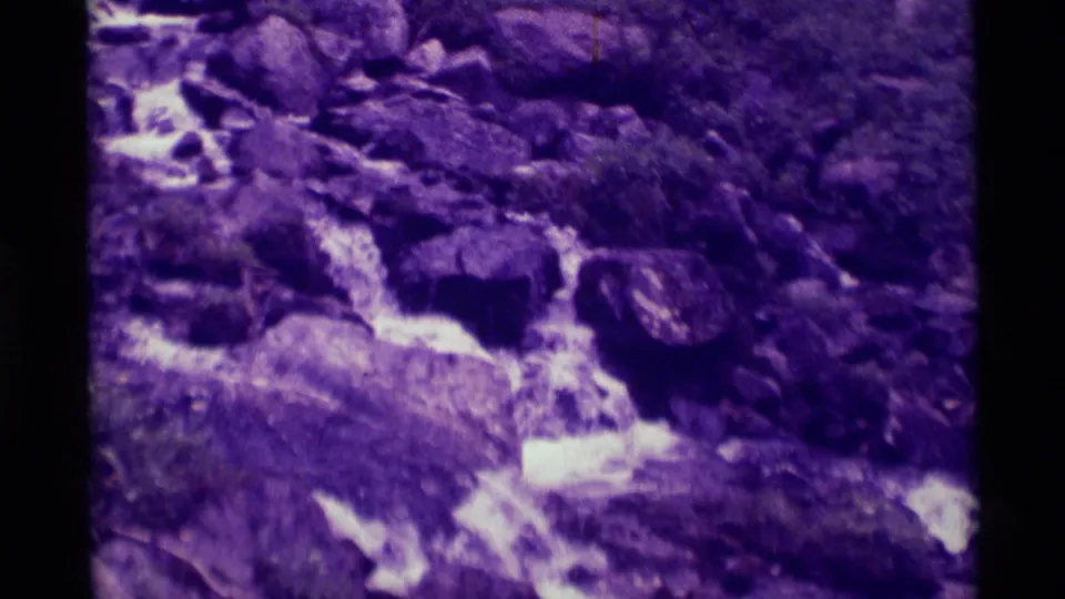 1975 8mm frame near Agate Springs, Montana, showing a small stream cascading through rocks after the hikers move from view.