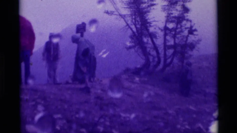 Soft 8mm view of visitors on a foggy Montana mountain trail, with rain droplets and trees dominating the frame.