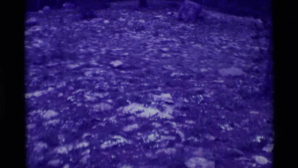 1975 8mm view from Agate Springs, Montana, showing rough stony terrain with heavy purple coloration and indistinct background forms.
