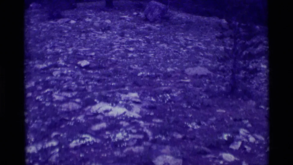 Agate Springs, Montana footage from 1975 showing rocky soil and faint vegetation, softened by grain and a strong purple-blue cast.