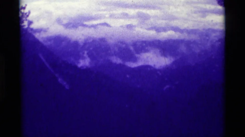 Agate Springs, Montana 8mm frame showing a soft clouded mountain landscape with dark borders and pronounced blue-purple tint.
