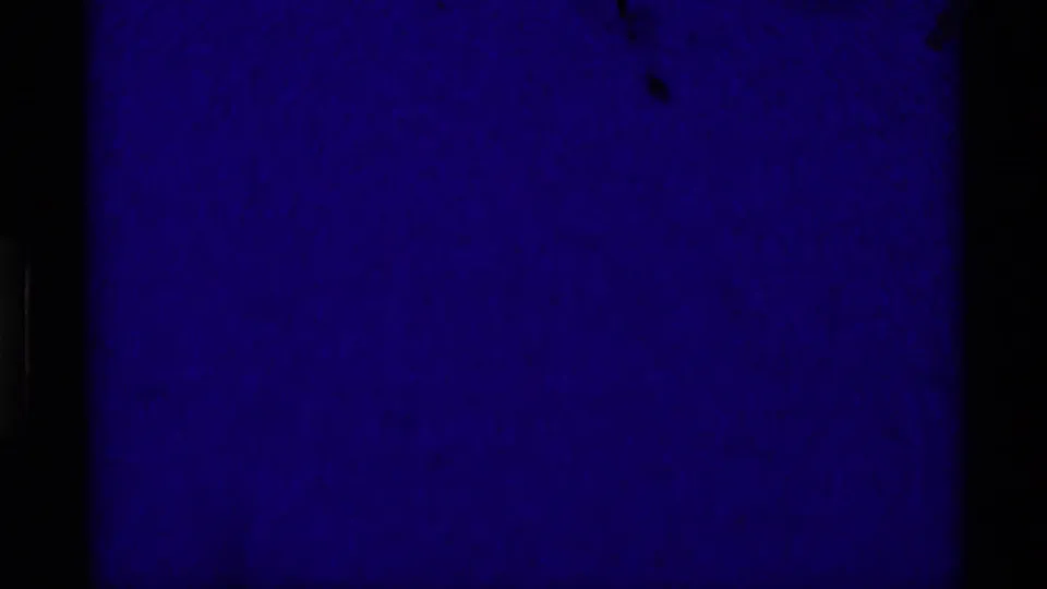 Underexposed 1975 8mm landscape frame dominated by deep blue density and faint terrain detail.