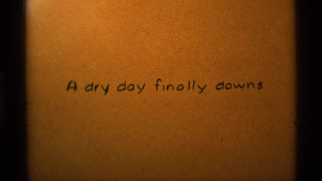 Handwritten title card on tan textured paper reading A dry day finally downs.