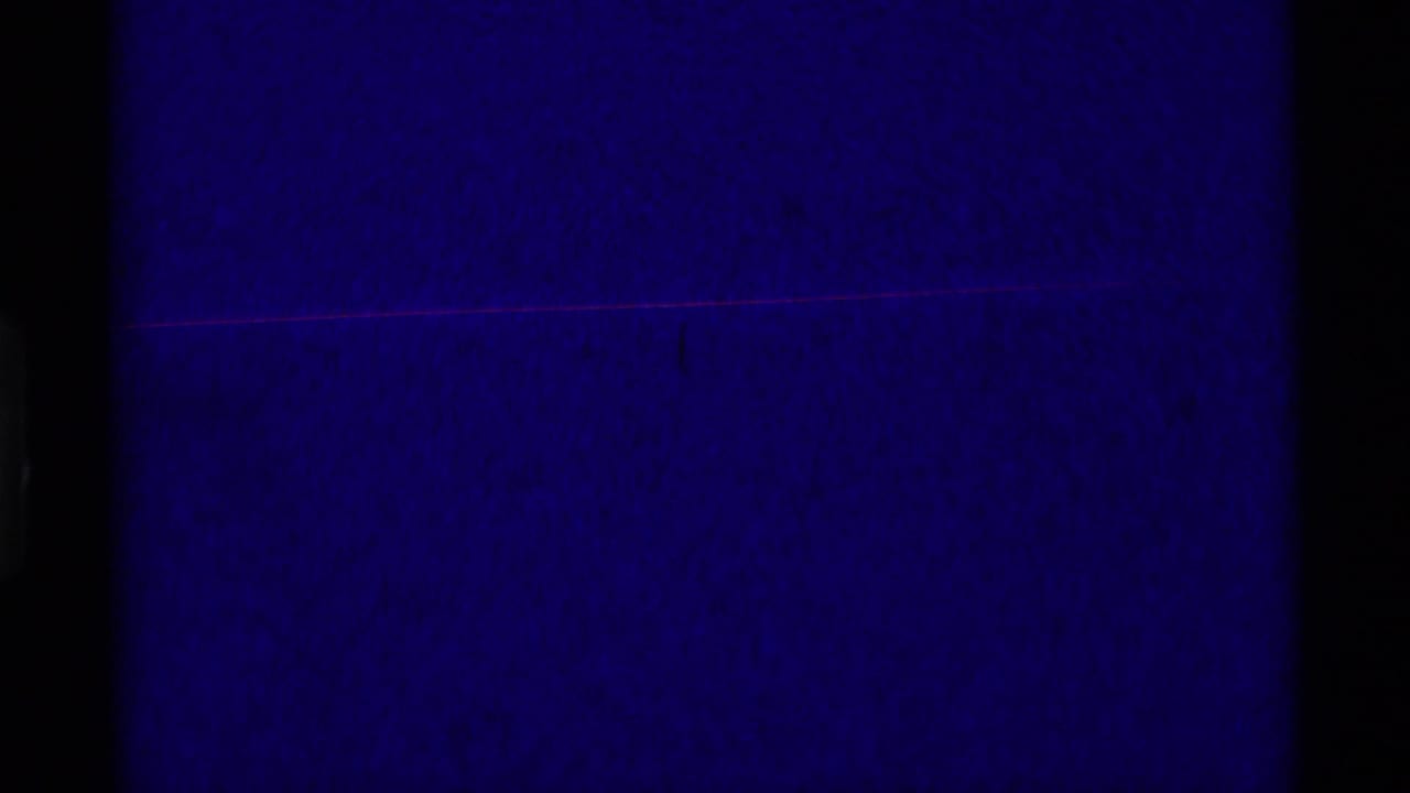 Dark blue-purple film frame with black borders and little visible subject detail.
