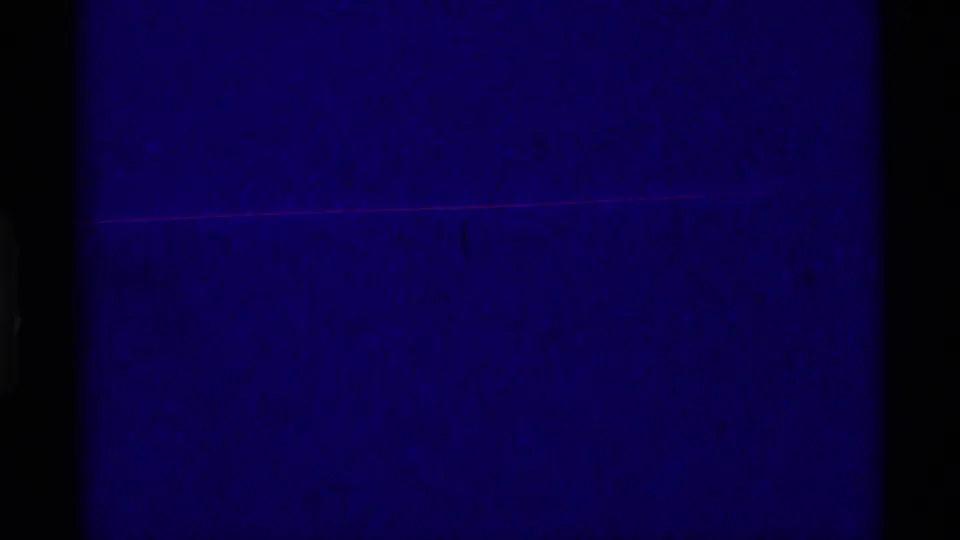 Opening 8mm frame appears mostly dark blue-purple, with heavy black borders and only faint film texture visible.