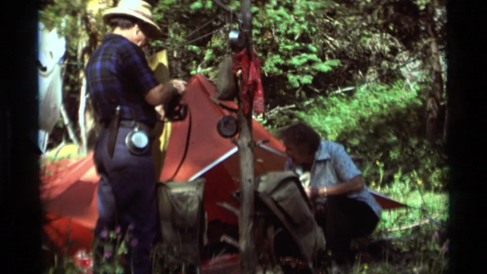 Agate Springs, Montana home-movie frame of campsite activity around a red tent and hanging equipment.