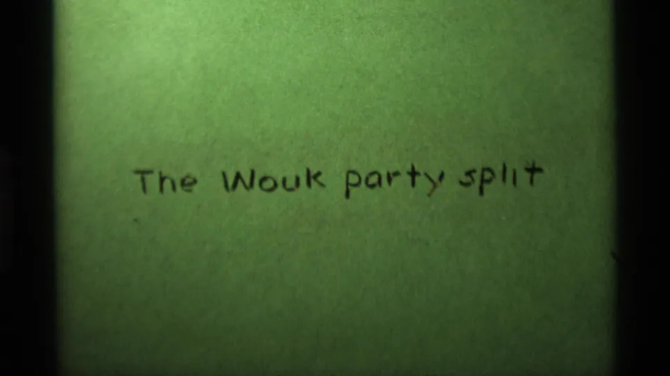 The handwritten green title card remains on screen, its black marker text reading The Wouk party split within the 8mm frame.