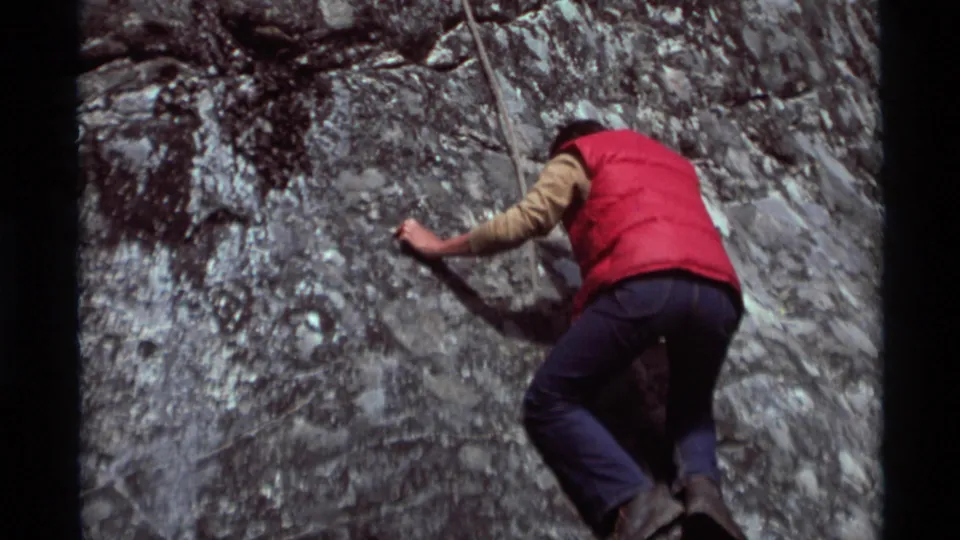 1975 Agate Springs, Montana frame showing the tethered climber extending an arm across the rock face during the ascent.