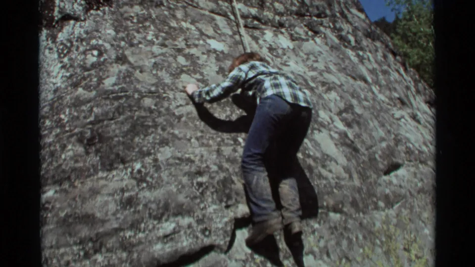 The final frame shows the 1975 Montana climber stretched against the lichen-marked rock, still relying on the rope.