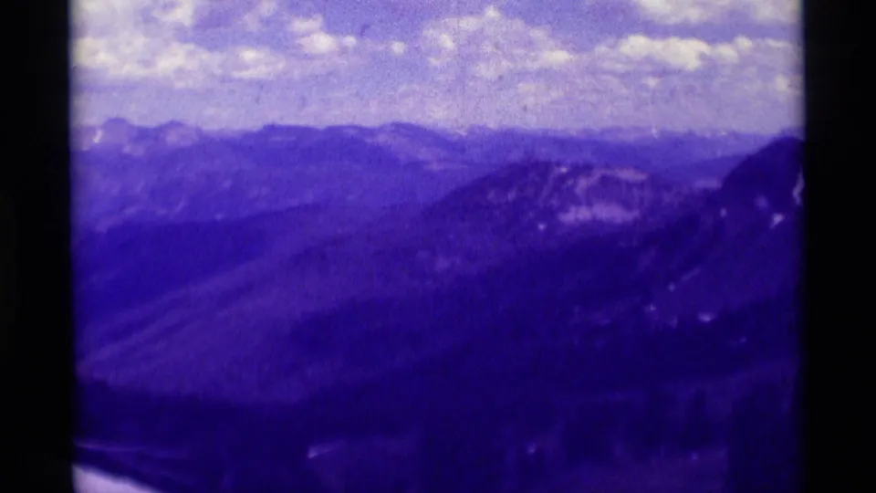 1975 8mm scenic view near Agate Springs, Montana, with layered ridges and a darker rocky slope entering the right side.