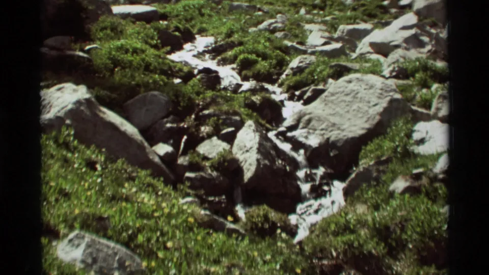 Final frame shows the snowmelt stream moving through boulders and spring vegetation in the Agate Springs, Montana mountain landscape.