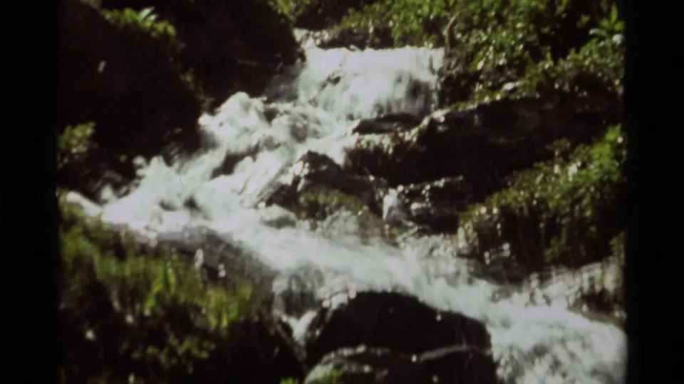 A soft 8mm close view shows foamy stream water tumbling over rocks in the Agate Springs, Montana landscape.