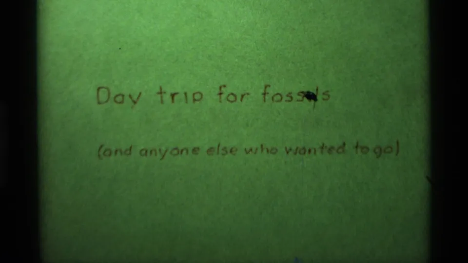 Handwritten green title card reads "Day trip for fossils" with a smaller note below, linking the scenic footage to a personal outing.