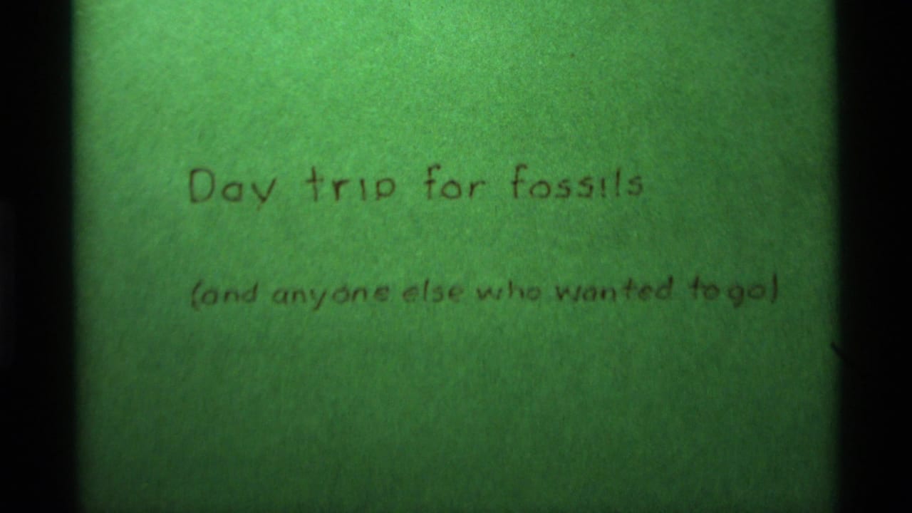 Handwritten fossil trip title card on a green background with dark film borders.
