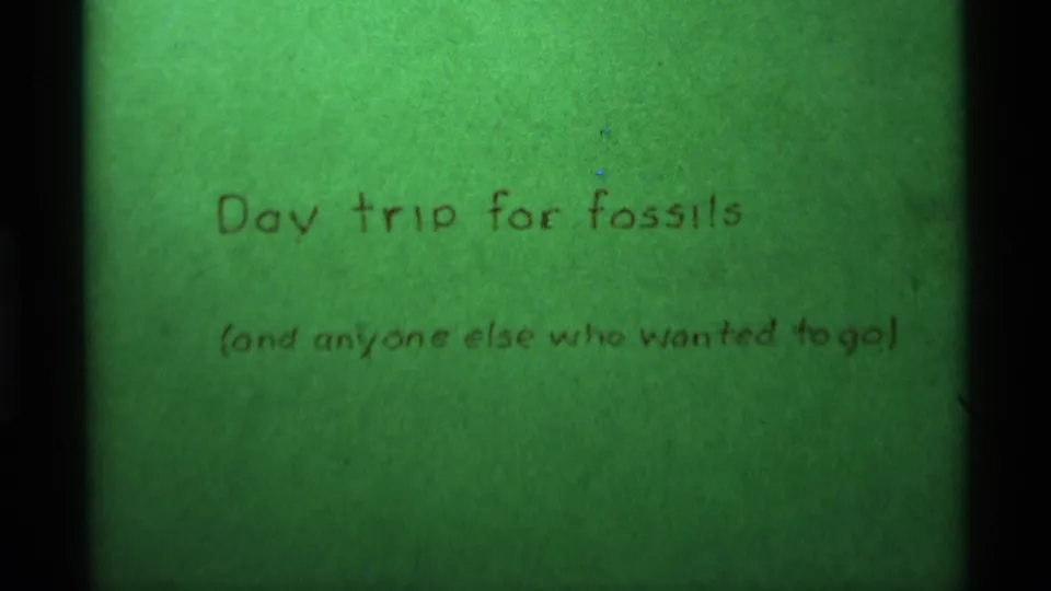 1975 8mm home-movie title card for a fossil day trip, filmed close up against a green background.