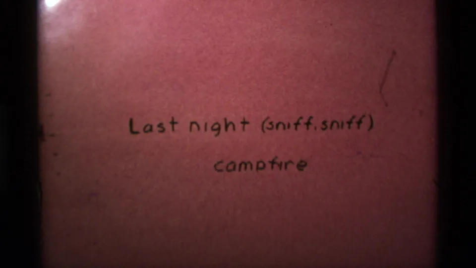 Handwritten 8mm title card reading Last night (sniff, sniff) campfire, likely part of the 1975 home-movie reel.