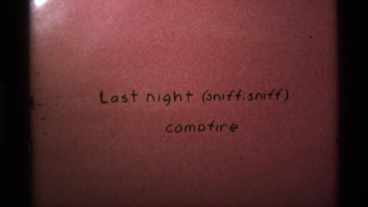 1975 8mm home-movie intertitle for a campfire scene in Agate Springs, Montana, with reddish tint and gate edges.