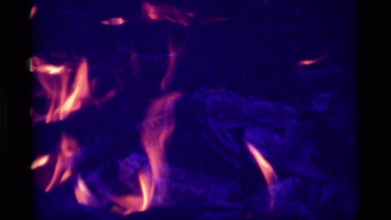 Dark fire scene with orange flame shapes and heavy blue-purple saturation.