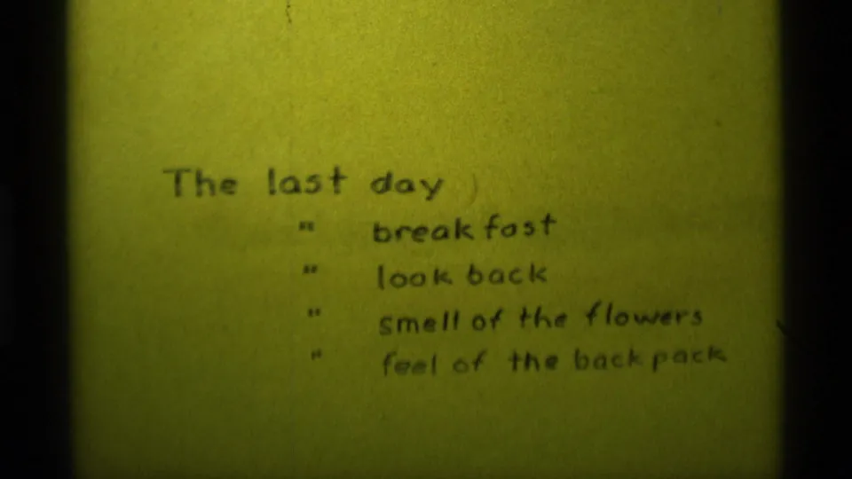 1975 8mm frame from the Montana home movie with the handwritten list slightly repositioned on yellow paper.