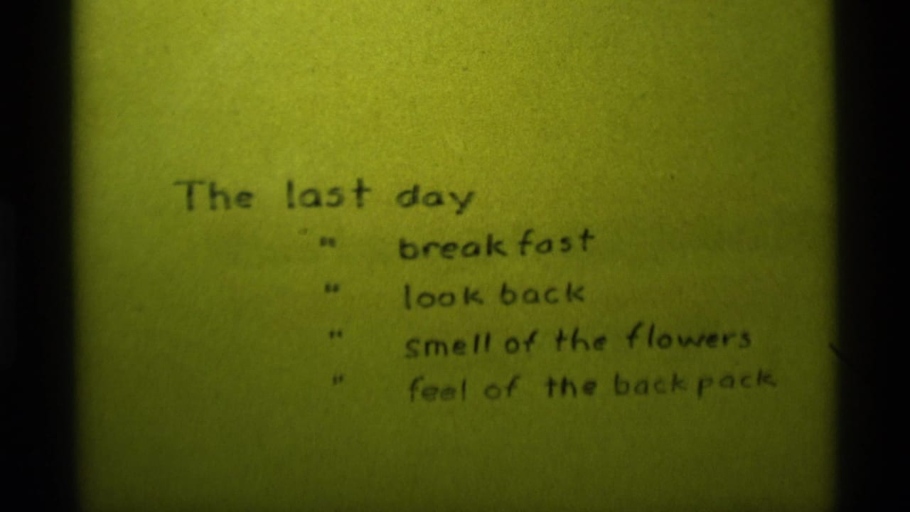 Repeated 1975 8mm title-card frame with handwritten final-day notes and visible film grain.