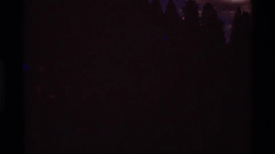 The final 1975 Montana frame is largely underexposed, with faint silhouettes of trees and the dark edge of the 8mm frame visible.