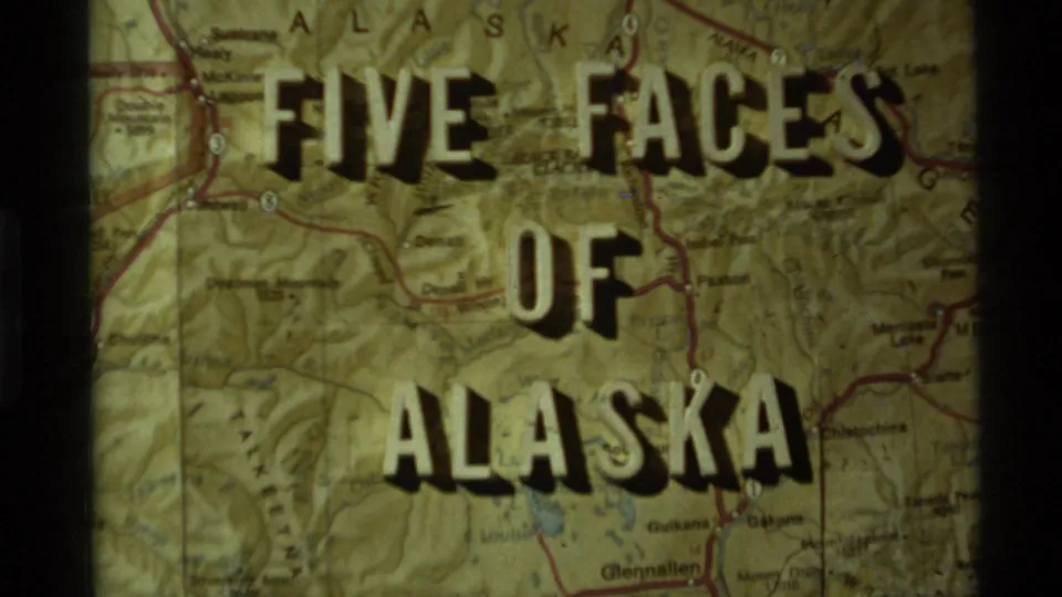 Alaska map title frame from a 1977 8mm reel, with bold lettering and visible projected-film border at the side.