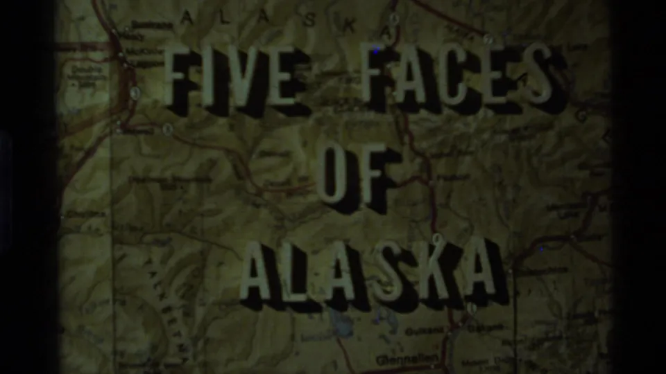 Second title-card frame from the Alaska home movie, with bold lettering over a map and dark projected borders.