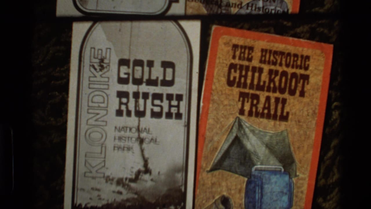 Close view of Klondike Gold Rush and Chilkoot Trail brochures with camping illustrations.