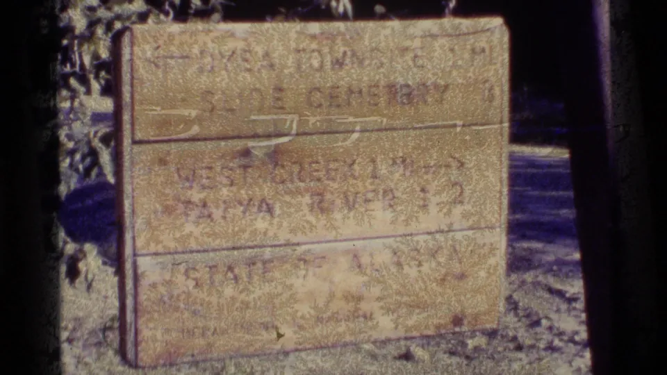 1977 Alaska travel footage showing a weathered wooden sign with directions including Dyea Townsite, Slide Cemetery, and Taiya River.