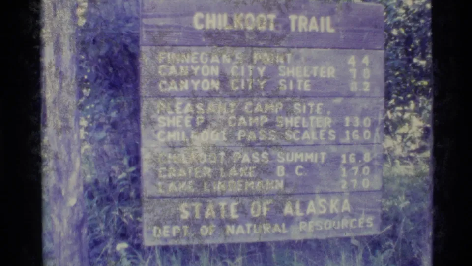 1977 Alaska 8mm frame showing a Chilkoot Trail distance sign from the State of Alaska Department of Natural Resources.