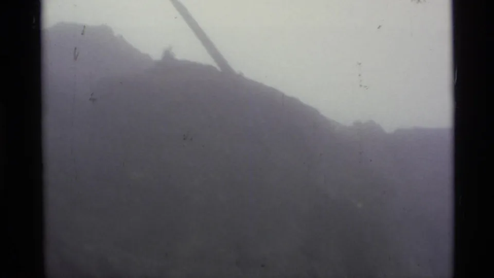1977 Alaska 8mm footage appears to show a fog-covered mountain slope with limited visibility and dark film-frame borders.