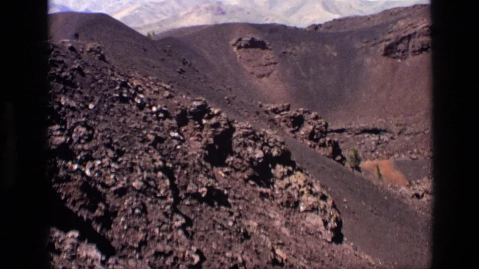 1972 Idaho 8mm still looking across rugged volcanic rocks, dark cinder slopes, and crater-like ridges.